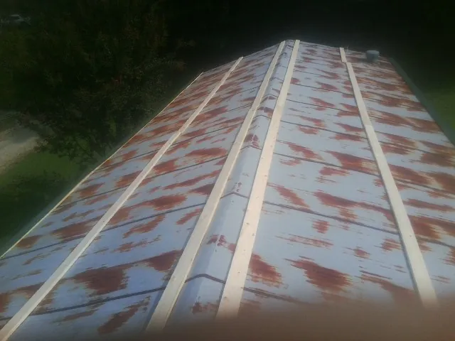 Rusted metal roof panels with new wood purlins before replacement — Storm Damage Roof Repair in Buford by Roofing Brothers